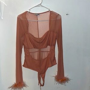 XL blush body suit with feathers on bottom of each sleeve
